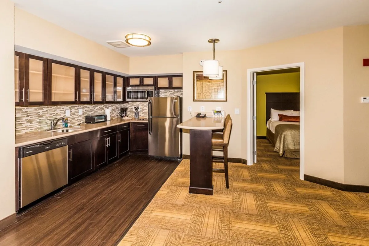 This image highlights the kitchen area with modern cabinets, stainless steel appliances, and a bar seating area. The space is set up for cooking, casual dining, or hosting—from morning coffee to celebratory meals.